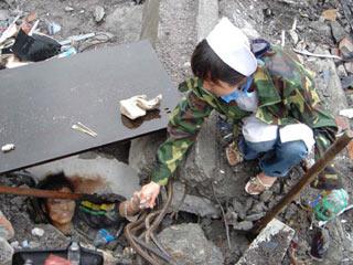 A nurse encourages a stranded child at the earthquake-hit Beichuan County, about 160 kilometers northeast of the epicenter of Wenchuan County, southwest China's Sichuan Province, May 13, 2008. Beichuan County is badly damaged in Monday's quake, with great numbers of buildings collapsed and landslides around the county.(Xinhua/Li Gang) 