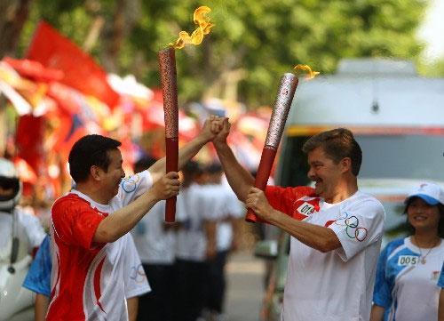 Pei Shaojun (left) takes over the Olympic torch flame to contimue the relay in Hangzhou city on Sunday, May 18, 2008.