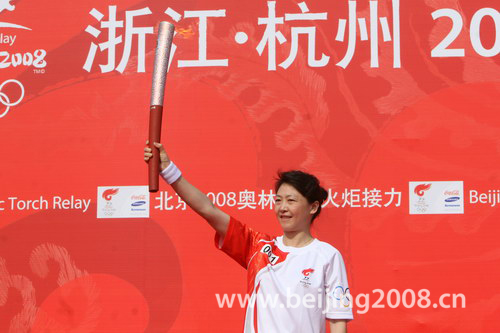 Photo: The first runner Li Lingwei holds the torch