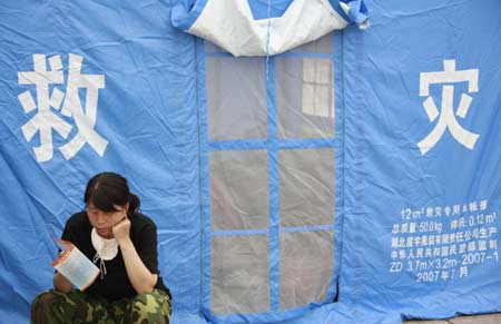 A victim reads a sanitation safety handbook outside the tent she living in at the temporary rescue center of the quake-hit Hanwang Township of Mianzhu City, southwest China's Sichuan Province, May 17, 2008. Houses in Hanwang Township, one of the worst-hit regions, have been almost all destroyed by Monday's earthquake.