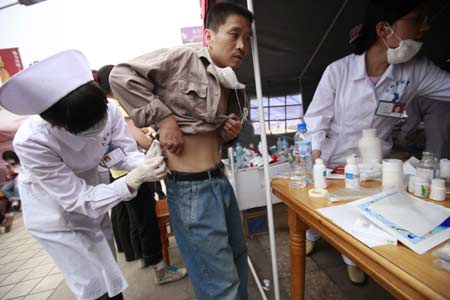 A medical worker treats a victim at the temporary rescue center of the quake-hit Hanwang Township of Mianzhu City, southwest China's Sichuan Province, May 17, 2008.