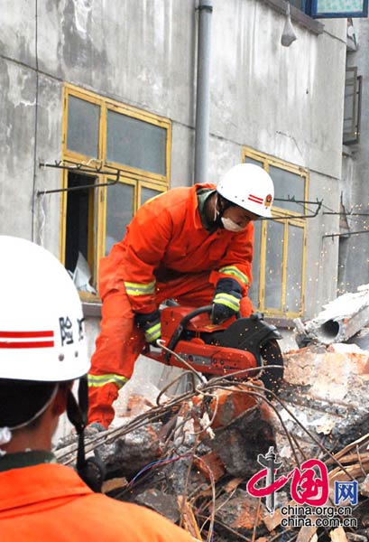 On the afternoon of May 16, firefighters detected signs of life in the wrecked staff quarters of the Jinhe Phosphate Rock Company in Hongbai Town. Picture shows firefighters cutting through steel reinforcing bars to gain access to the ruins.