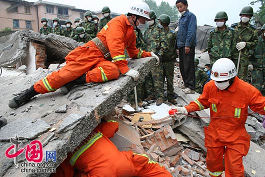 为了信号更加准确，消防队员不顾危险，将身体探入废墟中。武越明／摄影