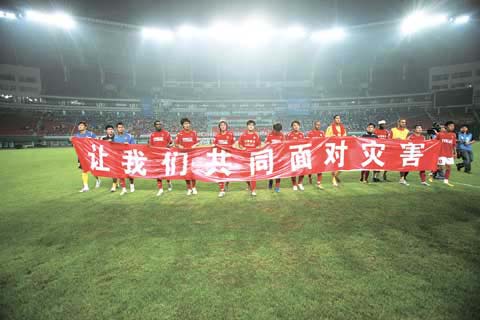 The Chengdu Blades football team, from the capital of the earthquake ravaged Sichuan Province, unfold a red scroll proclaiming 'Let's Face the Disaster Together,' in Changsha on Saturday, May 17, 2008. [Photo:hnol.net]