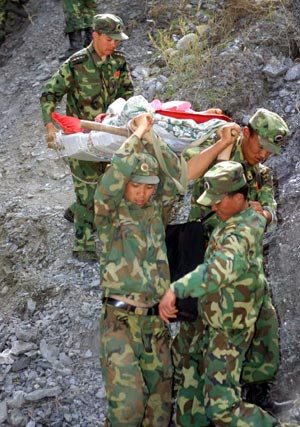  Soldiers carry an injured on a mountain road in the quake-hit Maoxian County, southwest China's Sichuan Province, May 18, 2008.