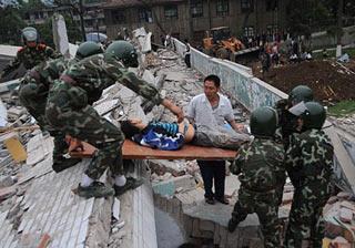 Relief soldiers carry out a wounded student from the ruins of a high school in the earthquake-affected Beichuan County, southwest China's Sichuan Province, on May 13, 2008. (Xinhua Photo)