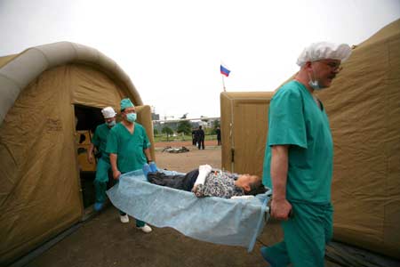 Two Russian surgeons shift an injured-citizen with stretcher to the inflatable wards after winding up the surgical operation, at Pengzhou, southwest China's Sichuan Province, May 21, 2008. The Russian medical team carried out surgical operations at the inflatable mobile hospital，comprising surgery rooms, patients’ward and other relevant facilities on Wednesday morning. 