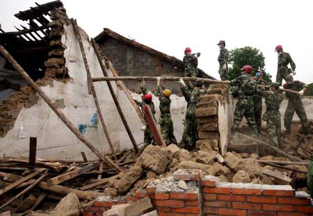 Frontier defense soldiers from south China's Guangdong Province help residents demolish ruined houses at Guanzhuang Village of Yonghe, a remote town in Anxian County, southwest China's Sichuan Province, May 21, 2008. Guangdong frontier defense soldiers on Wednesday arrived in Yonghe and Jiepai, remote towns in Anxian County, to carry out rescue work including search for survivors, epidemic prevention and help residents in their reconstruction. 