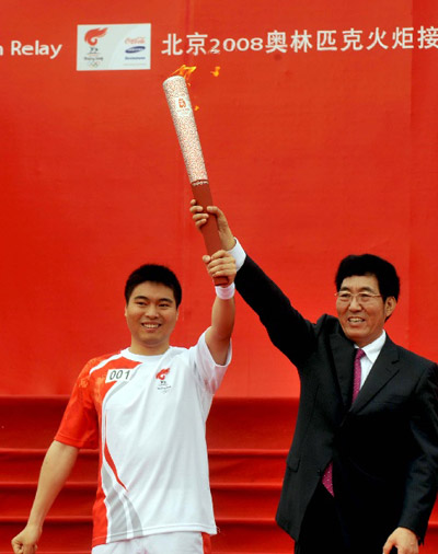 图文：奥运圣火在宁波传递 首棒火炬手展示火炬