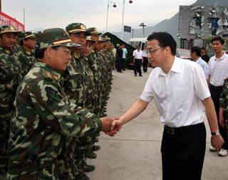 Li Keqiang (R Front), Chinese vice premier and member of the Standing Committee of the Political Bureau of the Communist Party of China (CPC) Central Committee, shaks hands with quake-relief soldiers near a tunnel at Xuankou Town of Wenchuan County, the epicenter of the May 12 magnitude 8 quake, in Chengdu, capital of southwest China's Sichuan Province, on May 20, 2008. (Xinhua/Lan Hongguang)