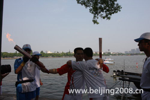 Photo: Torchbearers embrace during torch relay