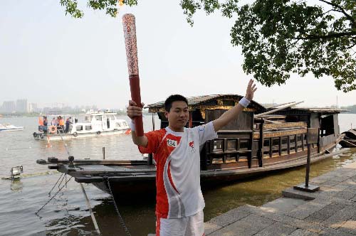 Photo: Torchbearer Chen Jun displays Olympic torch