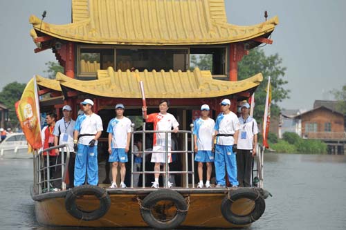 Photo: Torchbearer Fan Buxing relays Olympic torch by boat