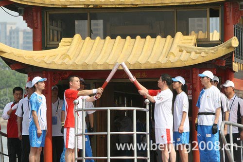 Photo: Torchbearers relay Olympic torch via boat