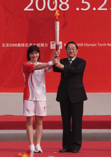 Shanghai Party chief Yu Zhengsheng (right) hands the Olympic torch to Zhuang Yong, the first torchbearer in the Shanghai leg of the torch relay, this morning near Shanghai Museum at People's Square.