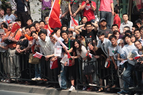 People line a street to cheer during the Olympic torch relay in Shanghai this morning. The Olympic flame arrived in Shanghai last night after the relay was suspended for three days to mourn victims of the Sichuan earthquake.