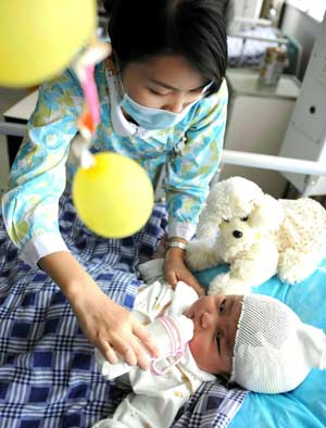 A nurse milks seven-month-old Cao Wenxi in the intensive care unit (ICU) of Xinqiao Hospital under the Third Military Medical University in Chongqing Municipality in southwest China, May 23, 2008. Cao Wenxi, injured in the May 12 quake in Mianzhu of southwest China, was given an operation in the hospital. He gained 1,500 grams and is in good condition, according to the hospital workers. 