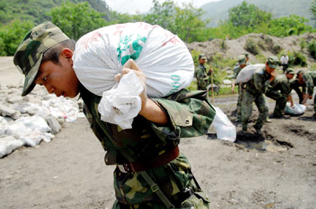 Soldiers carry sandbags to reinforce the bridge foundation in Nanba Town of Pingwu County under Mianyang City, southwest China's Sichuan Province, May 22, 2008. The only bridge in Nanba Town was destroyed in the May 12 quake mainly hitting Sichuan Province. Soldiers of the Chinese People's Liberation Army built a floating bridge instead within three days, which speed up the rescue work in the area.