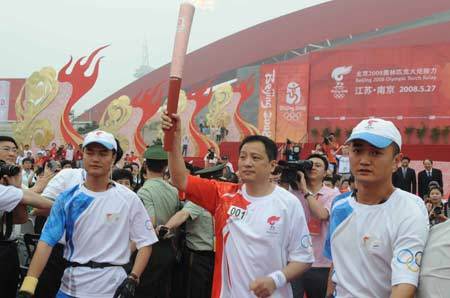 The Beijing Olympic torch relay kicks off in Nanjing, the capital city of Jiangsu Province on Tuesday May 26, 2008. The first torchbearer Yang Yang(C) holds the torch at the beginning of the relay.