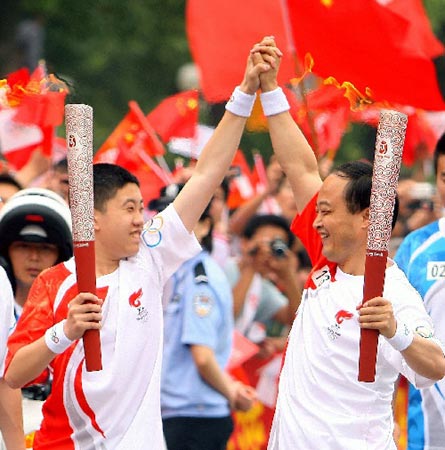 Photo: Torchbearers pass on Olympic torch