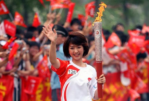 Photo: Torchbearer Shen Jie runs with Olympic torch