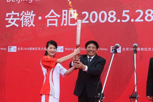 Olympic diving champion Li Na (Left) holds the Beijing Olympic torch with Sun Jinlong (Right), secretary of Hefei Committee of the CPC at the starting ceremony of the torch relay in Hefei, Anhui Province, on Wednesday, May 28, 2008. [Photo: beijing2008.cn]