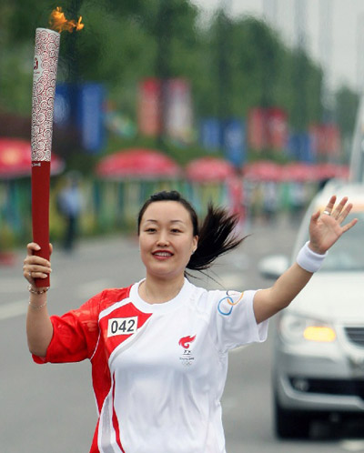 Photo: Torchbearer Wang Xia runs with the torch in Hefei