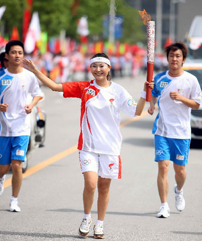 Photo: Torchbearer Zhu Lingmin runs with the torch in Hefei