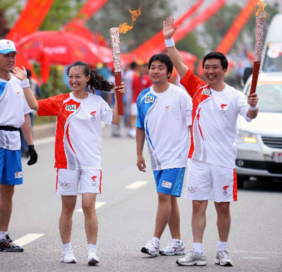 Photo: Torchbearers Wei Zhen and Jiang Zhuo wave to the audience