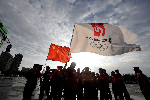 Photo: Local people wave flags waiting for the torch relay in Hefei