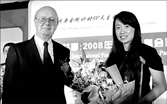 French diplomatic analyst Ed Damazin Marquis presents flowers to fencing Paralympian Jin Jing at the International Forum on the 2008 Paralympic Games in Beijing yesterday. 