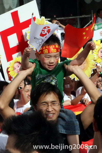 Photo: A father and his son cheer the torch relay in Huainan