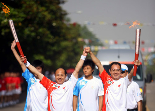 Photo: Two torchbearers celebrate after their torch relay in Huainan