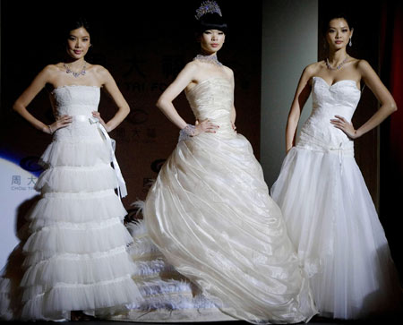 International super model Lu Yan (C), Hong Kong model Gaile Lai (L) and Taiwan model Patina Lim display wedding dress and jewellery designes in Hong Kong, south China, May 29, 2008.