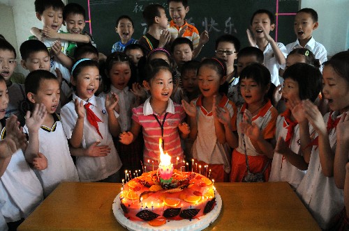 Students in a primary school in Yichang city of Central China's Hubei Province celebrate International Children's Day with Zhu Haiwen (C), a girl from the quake-stricken Sichuan Province, May 29, 2008.