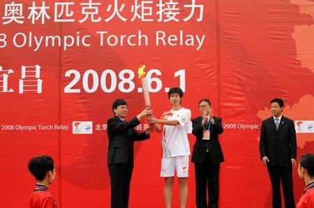 Torchbearer Li Ting (L2) holds the torch on the openning ceremony of the 2008 Beijing Olympic Games torch relay in Yichang, Central China&apos;s Hubei Province, June 1, 2008. 