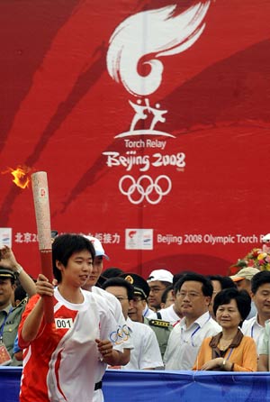 Torchbearer Li Ting runs with the torch during the 2008 Beijing Olympic Games torch relay in Yichang, Central China&apos;s Hubei Province, June 1, 2008. 