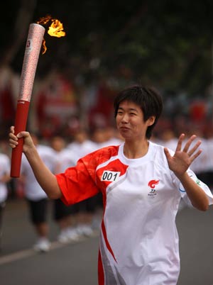 Torchbearer Li Ting runs with the torch during the 2008 Beijing Olympic Games torch relay in Yichang, Central China&apos;s Hubei Province, June 1, 2008. 