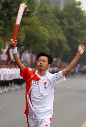 Torchbearer Li Shaoping runs with the torch during the 2008 Beijing Olympic Games torch relay in Yichang, Central China&apos;s Hubei Province, June 1, 2008. 