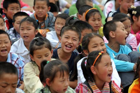 Pupils sing songs to celebrate the children's day on the playground in a primary school in Dongbei Town, Mianzhu City, southwest China's Sichuan Province, May 31, 2008.