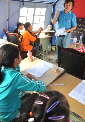 A volunteer and children do the rehearsal of performances for the upcoming International Children's Day in quake-hit Yingxiu Town of Wenchuan County, southwest China's Sichuan Province, May 31, 2008.