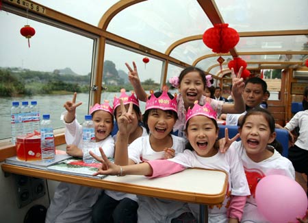 Children from quake-hit areas in Sichuan Province, accompanied by their new classmates, visit the Lijiang River in Guilin, south China's Guangxi Zhuang Autonomous Region, May 31, 2008. Some children transferred from quake-hit areas to other places in China celebrated the upcoming International Children's Day which falls on June 1.