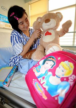 Gou Fei from Dujiangyan plays with her toy bear at a hospital in Chengdu, capital of southwest China's Sichuan Province, May 31, 2008. The International Children's Day falls on June 1. Children in quake-hit areas in China are optimistic about their future. 