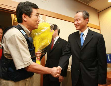 Chinese Ambassador to Japan Cui Tiankai(R) shakes hands with the captain of the Japanese medical team at the Narita airport in Chiba Prefecture, Japan, June 2, 2008.
