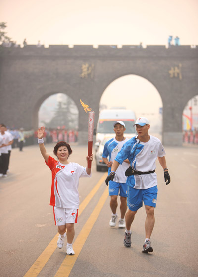 Photo: Torchbearer Ma Junliu runs with the torch in Jingzhou