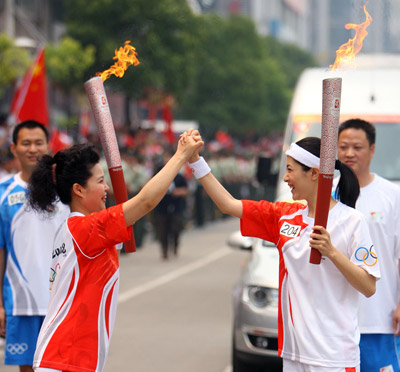 Photo: Torchbearers Zeng Li and Meng Ge celebrate during the torch relay in Jingzhou