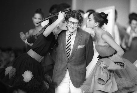 French designer Yves Saint Laurent is kissed by models at the end of his fashion show in Paris in this October 21, 1987 file photo. French fashion king Laurent, hailed for revolutionising the way women dressed, died on June 1, 2008, a close associate told France Info Radio. 