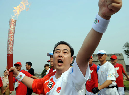 Photo: The 9th torchbearer celebrates with the torch in Yueyang