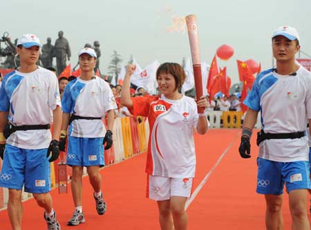 The Beijing 2008 Olympic torch relay kicks off in in Xiangtan City, central China's Hunan Province on June 5, 2008. Photo shows the first torchbearer Yang Xia (2nd R) in the torch relay procession. 