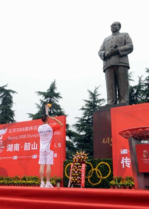 Torchbearer Jiang Aibing salutes to the bronze statue of Mao Zedong before he lights the cauldron during the closing ceremony for the 2008 Beijing Olympic Games torch relay at Mao Zedong Square in Shaoshan, known as the hometown of Mao Zedong, central China's Hunan Province, June 5, 2008.